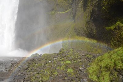 Foto eines Regenbogens in der Gischt eines Wasserfalls in Island